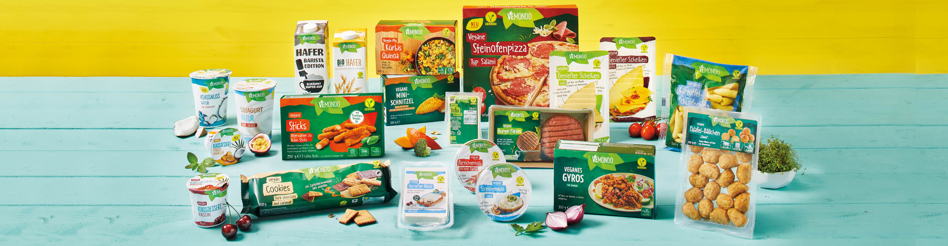 Asortiman veganskih proizvoda VEMOND, uključujući pizzu, burgere, jogurte, kekse i biljne napitke.