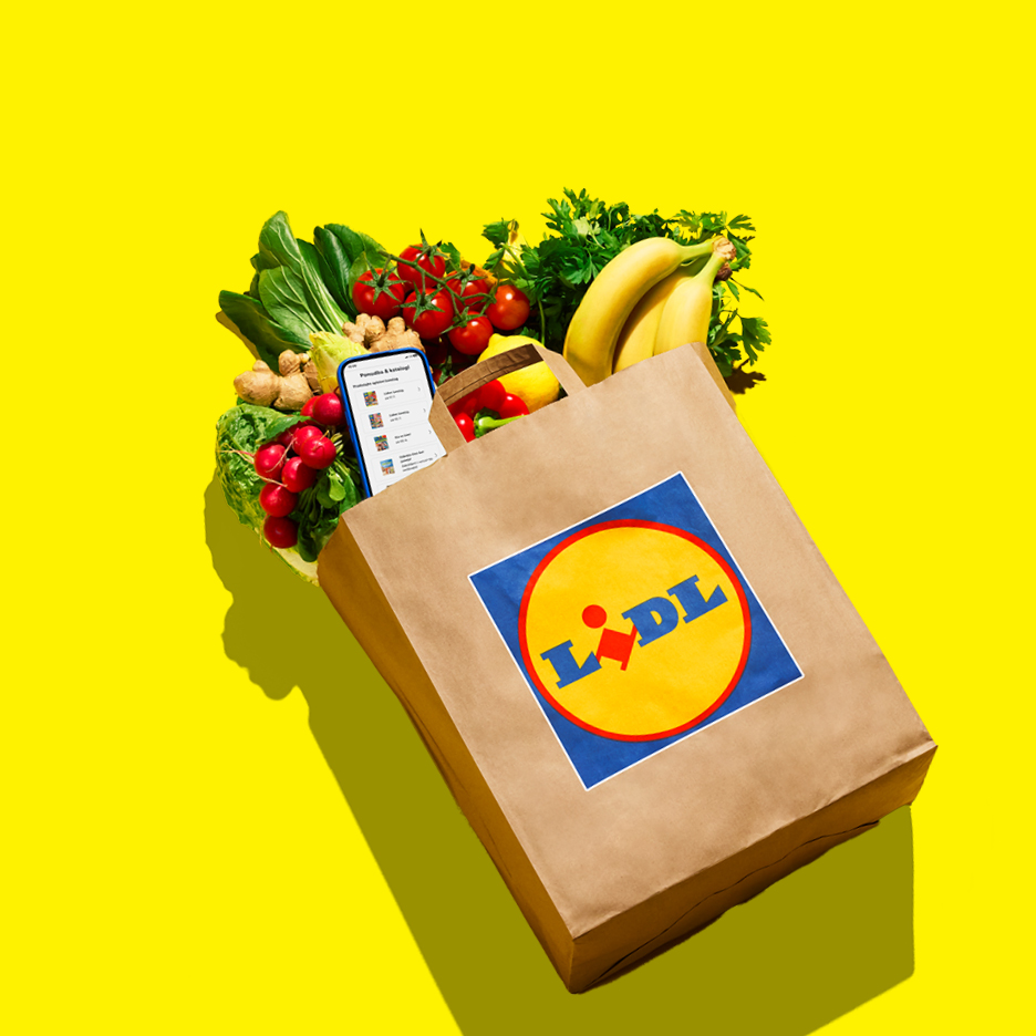 Papirnata vrećica s namirnicama, uključujući banane, rajčice, rotkvice i zeleno lisnato povrće.