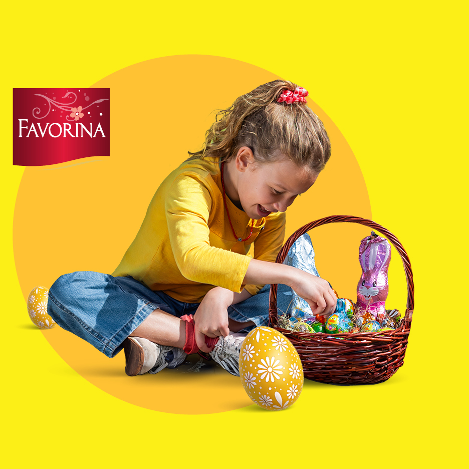 Djevojčica s košarom punom čokoladnih zečeva i uskršnjih jaja na žutoj pozadini.