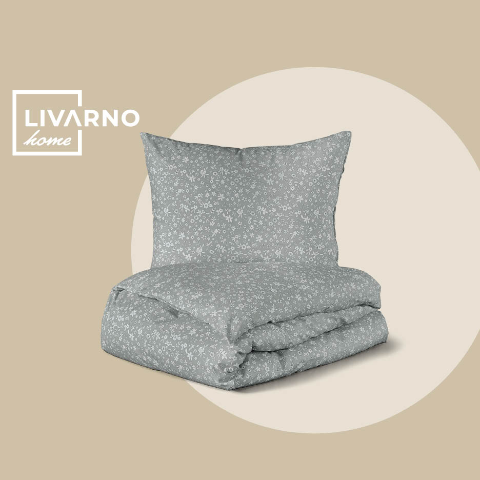 Sivi set posteljine s cvjetnim uzorkom, uključujući jastuk i poplun.