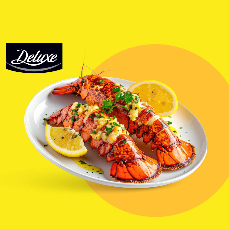 Kuhani repovi jastoga s limunom i peršinom na bijelom tanjuru.