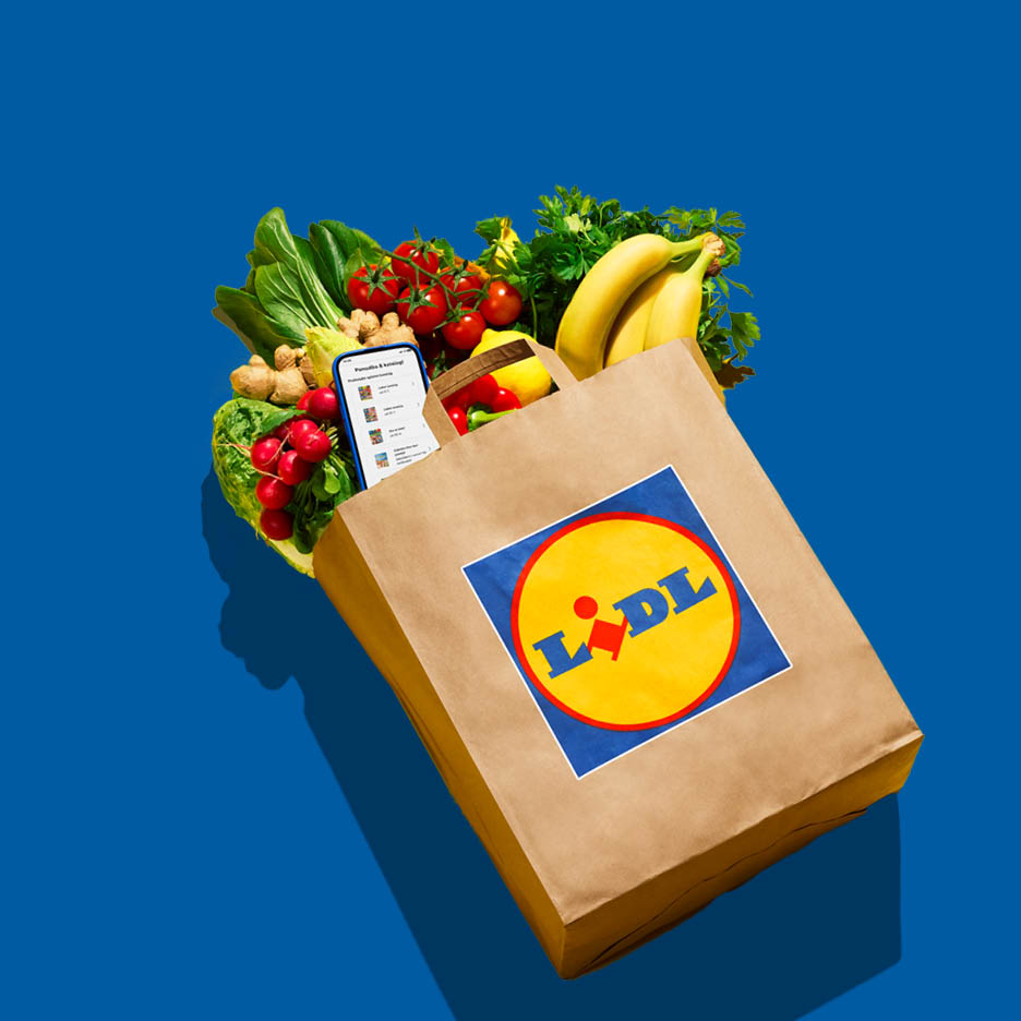 Papirnata vrećica puna svježeg voća i povrća, s pametnim telefonom koji prikazuje popis za kupovinu.