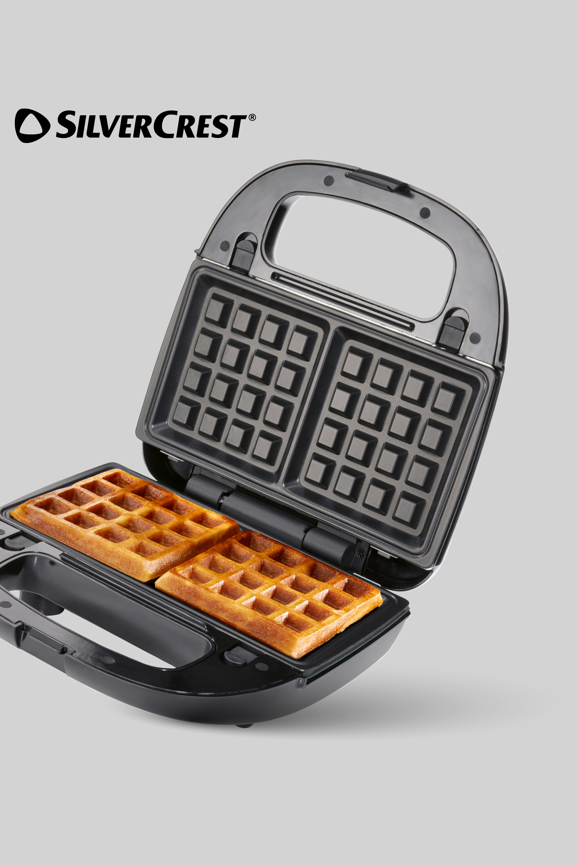 Otvoreni aparat za vafle s dva svježe pečena vafla unutra.