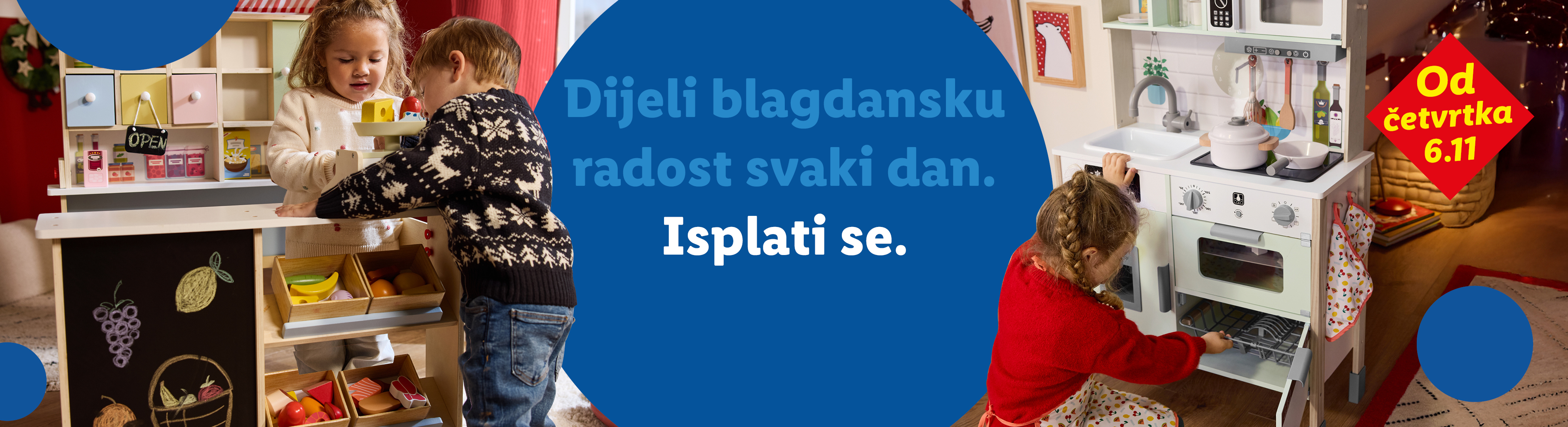 Dvoje djece igra se s drvenom kuhinjom i štandom s hranom. Tekst: 'Dijeli blagdansku radost svaki dan. Isplati se. Od četvrtka 6.11'